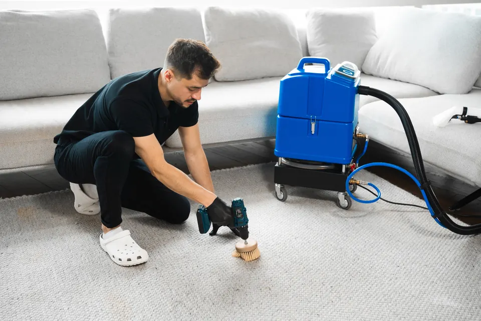 Equipo de inyección y extracción trabajando sobre una alfombra en el salón de una vivienda