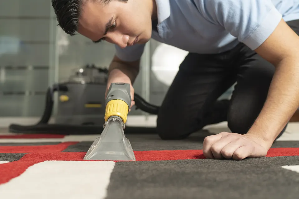 Técnico aplicando extracción con agua caliente sobre una alfombra